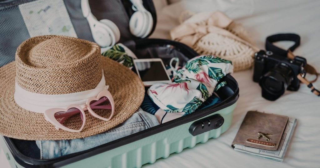 Travel essentials checklist with neatly packed suitcase and passport