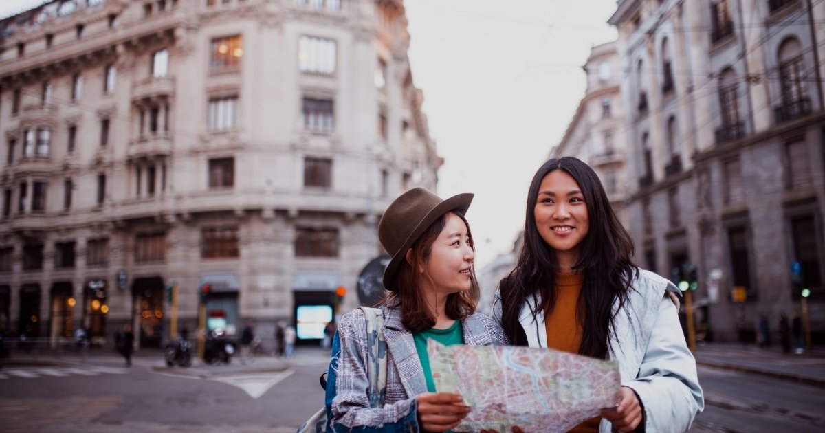 Traveller using a phone for directions in a city while staying aware of surroundings